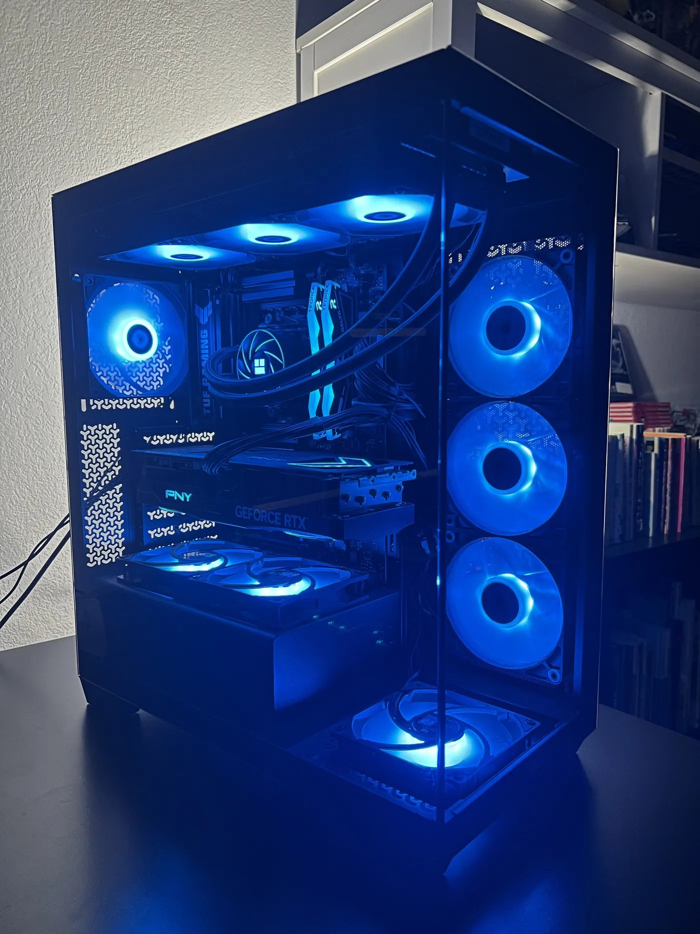 Black Corsair 3500X gaming PC with ice-blue ARGB fans, a PNY GeForce RTX 5070 Ti and a 360 mm Thermalright liquid cooler, glowing on a desk